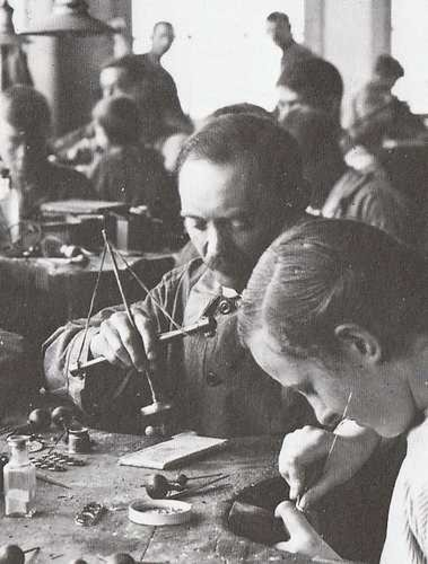 Maurits van de Waal gezeten achter de werktafel op het atelier van de firma Van de Waal te Schoonhoven. Hier bedient hij een zogenaamde pompboor [1920]
Privé-collectie